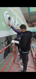 Two workers inspecting wall installations.